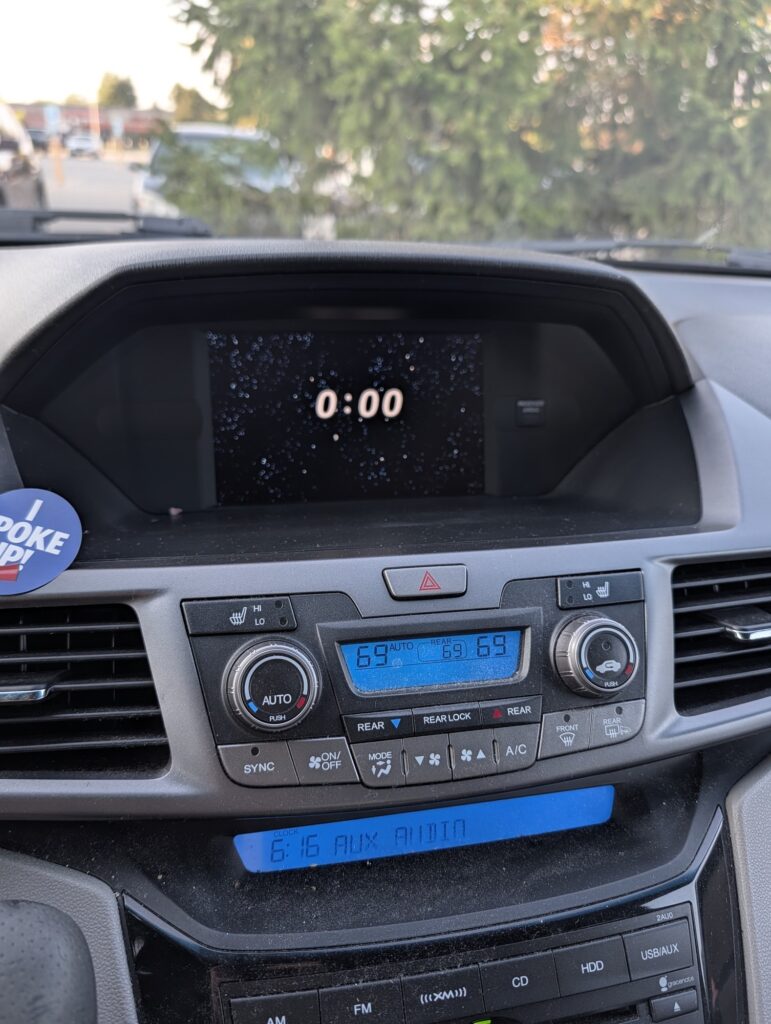A navigation clock stuck at 0:00 above an audio display that shows the correct time, 6:16.